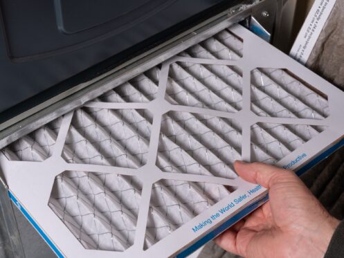 Man replacing a dirty furnace filter