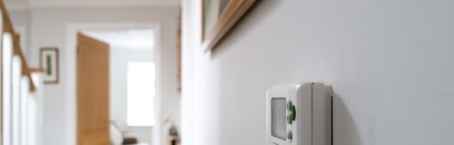 Thermostat in a hallway next to stairs