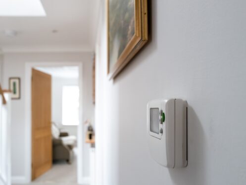 Thermostat in a hallway next to stairs